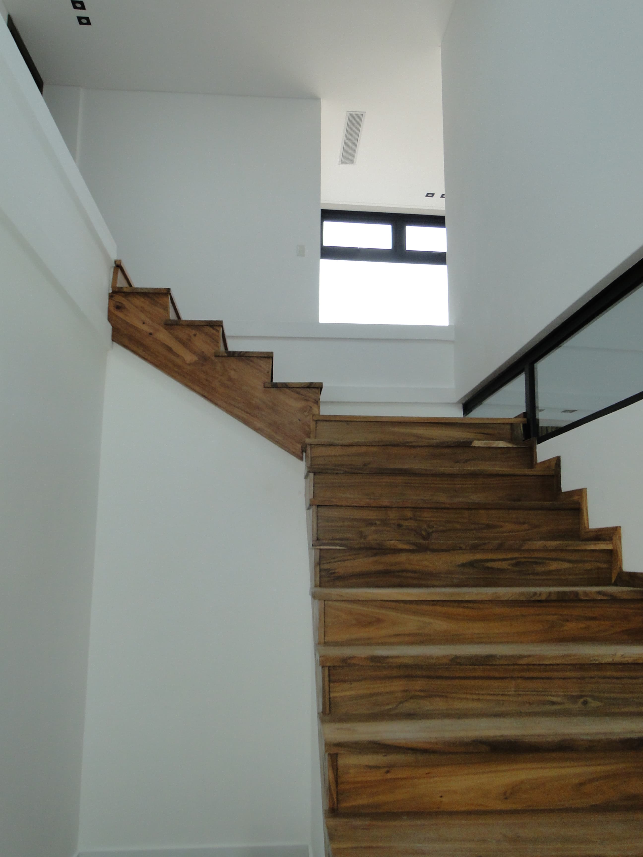 Escalera de madera flotante con baranda de vidrio