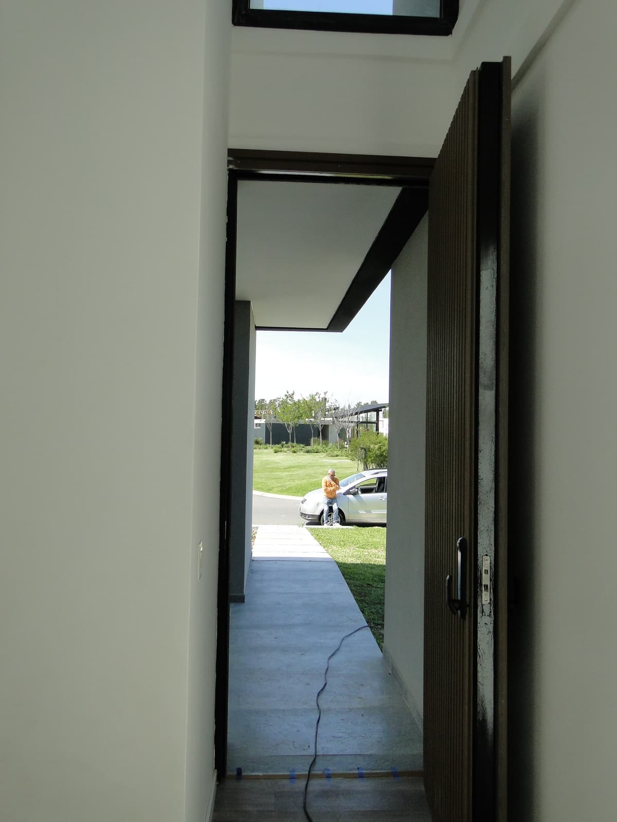 Puerta de acceso pivotante con diseño de listones