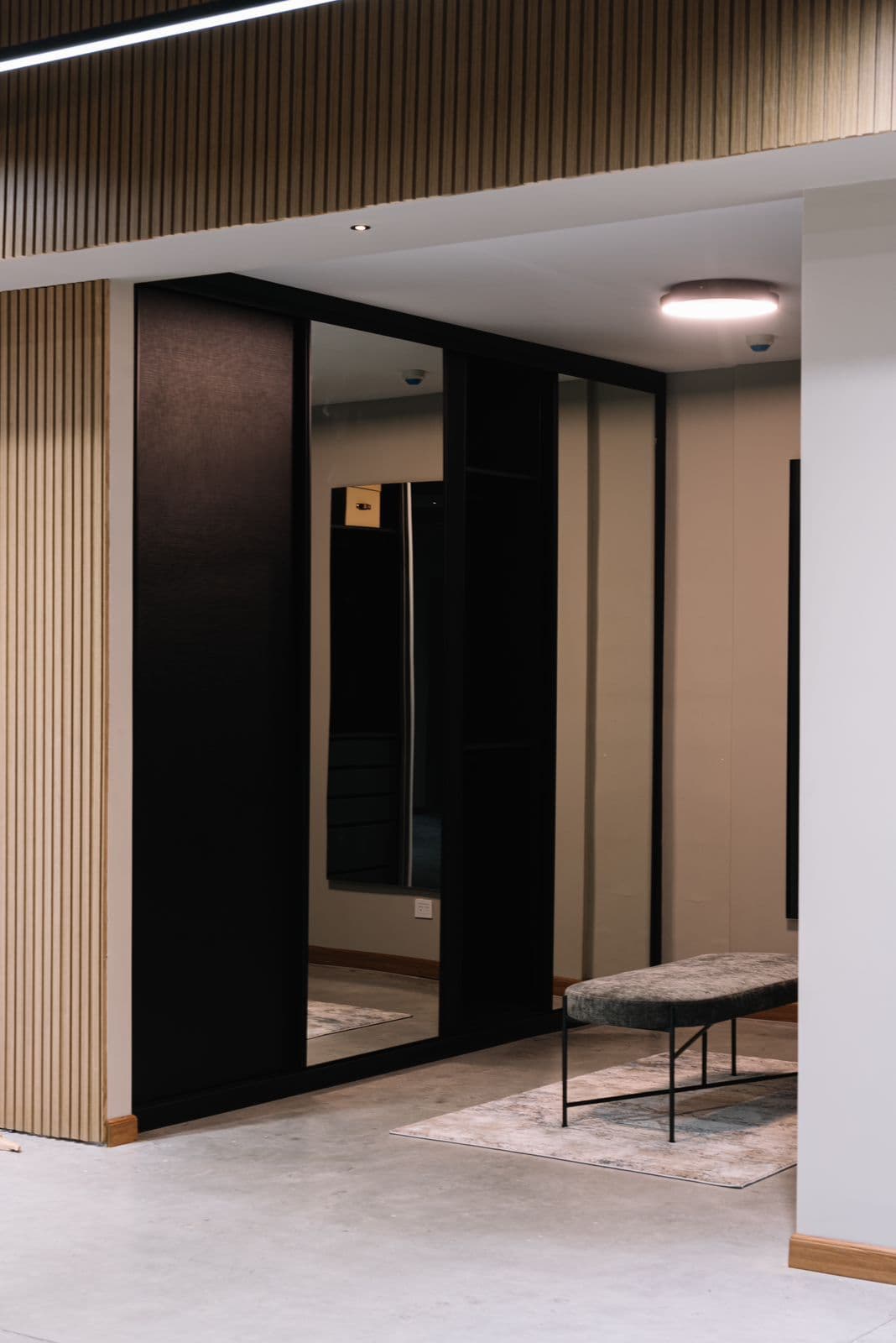 Vestidor con puertas negras y espejo