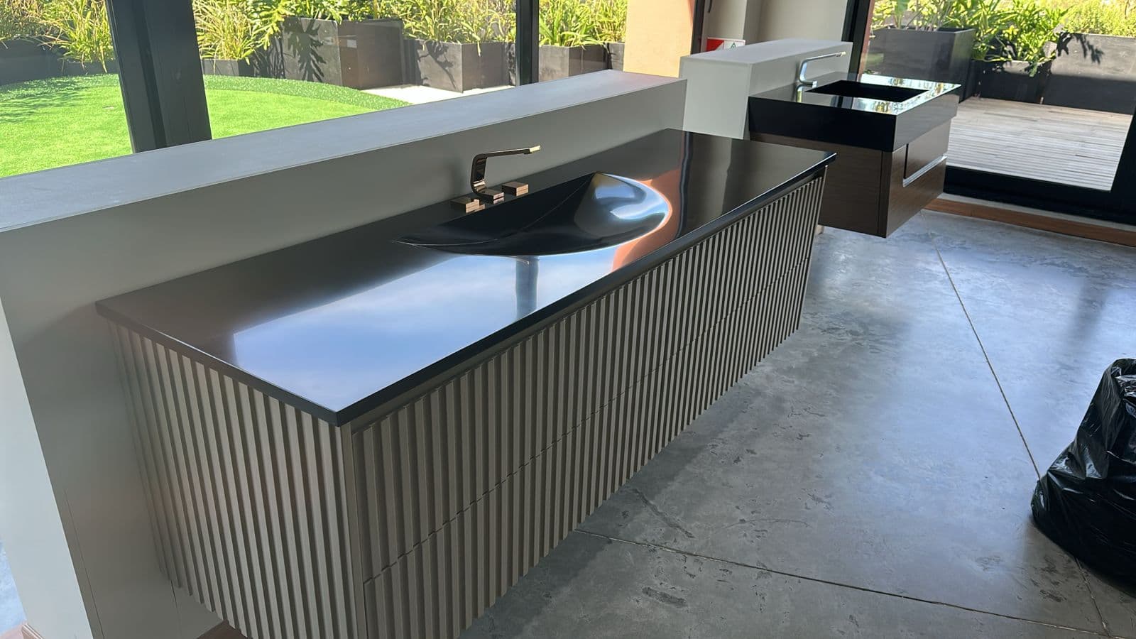 Baño moderno con mesada negra y grifería dorada